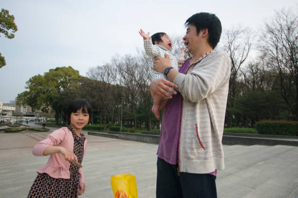 istock Father in a park with daughter and baby 944407098