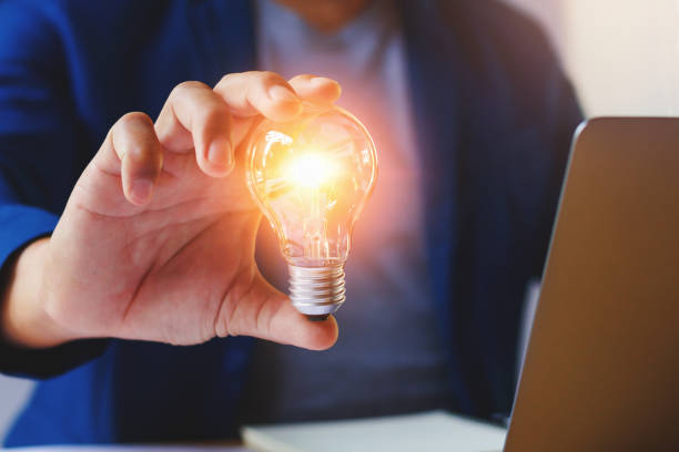 istock businessman holding lightbulb in office. creative idea for saving energy. concept finance 944409610