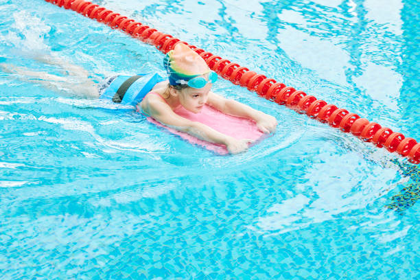 istock Determined girl swimming with kickboard 944424828
