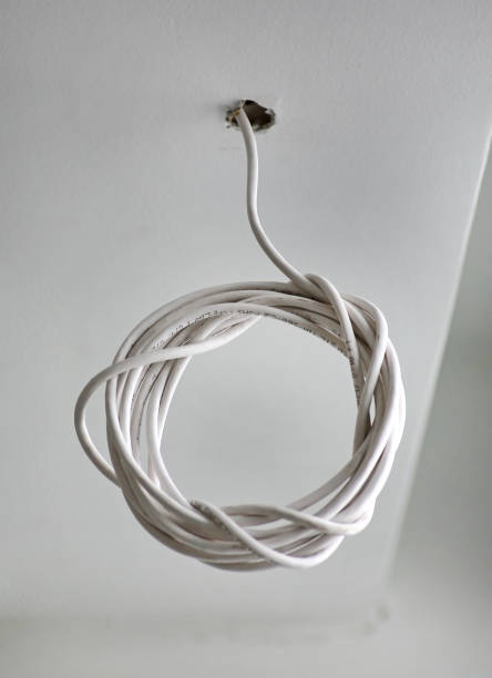 istock Bundle of CCTV cables are hanging from above in the building. 944444672