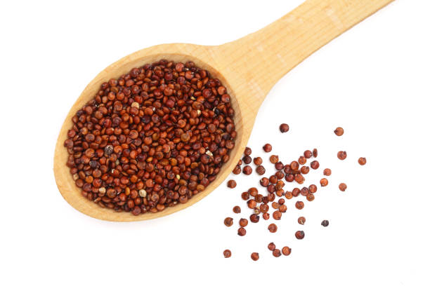 istock red quinoa seeds in wooden spoon isolated on white background. Top view 944449938