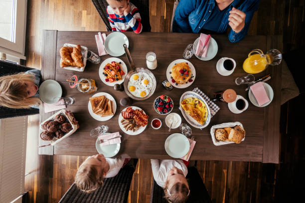 istock Eating Delicious Breakfast with Eggs, Bacon, Waffles, Croissants and Fresh Fruits 944461920