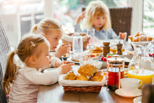 istock Eating Delicious Breakfast with Eggs, Bacon, Waffles, Croissants and Fresh Fruits 944461992