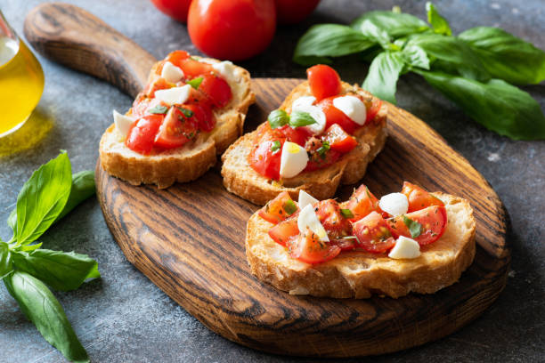 istock Bruschetta with cherry tomatoes and mozzarella cheese on wooden cutting board 944462148