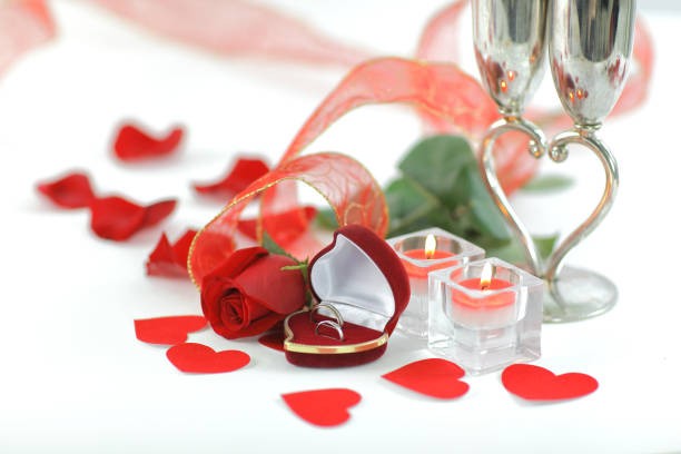 istock wedding rings, candles and rose on white background 944465074