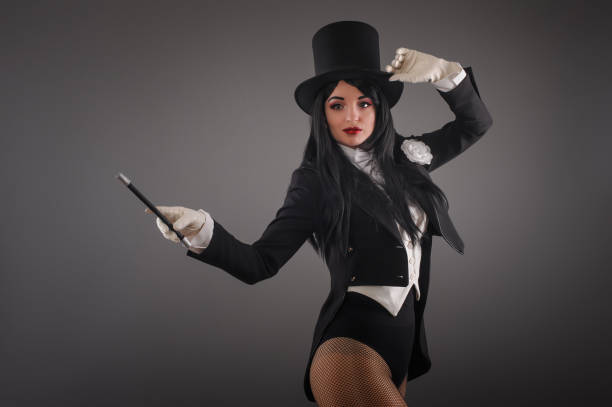 Female magician in costume suit with magic stick doing trick Beautiful female magician dressed in costume suit with magic stick doing trick. Studio shoot female magician stock pictures, royalty-free photos & images