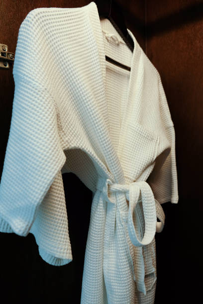 istock White bathrobe with hanger in wardrobe at hotel room 944468610