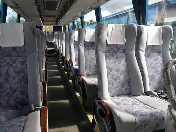 Empty bus passenger seats with seatbelt and head cloth stock photo