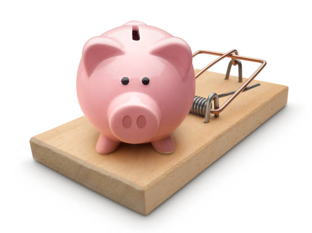 istock Piggy bank in a mousetrap on white background 944474498