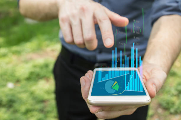 istock Augmented reality technology for personal use and financial charts and graphs.  Mobile device in hands. 944474564