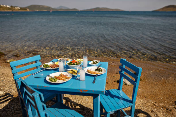 istock Appetizers and Raki or Ouzo Served on a Blue Table on the Beach Besides Beautiful Sea View 944477878