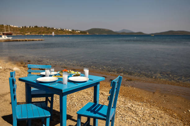 istock Appetizers and Raki or Ouzo Served on a Blue Table on the Beach Besides Beautiful Sea View 944477930