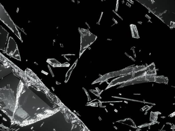 istock Broken shattered glass pieces isolated on black 944478036