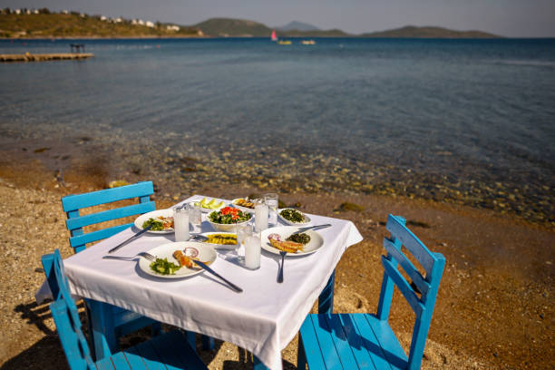 istock Appetizers and Raki or Ouzo Served on a Blue Table with White Table Cloth on the Beach Besides Beautiful Sea View 944478128