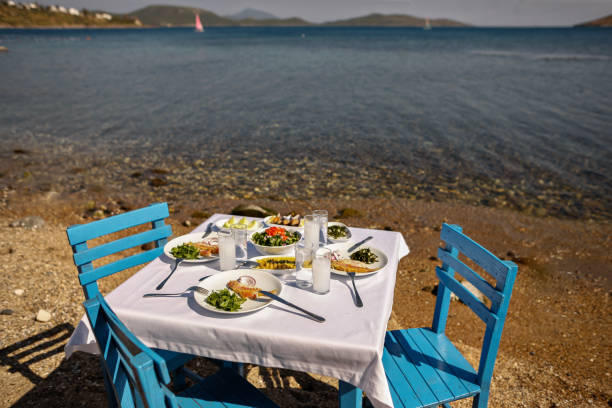 istock Appetizers and Raki or Ouzo Served on a Blue Table with White Table Cloth on the Beach Besides Beautiful Sea View 944478212