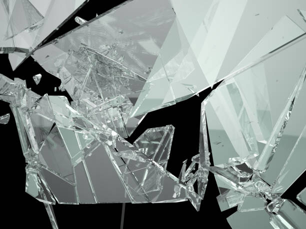 istock Broken shattered glass pieces isolated on black 944478240
