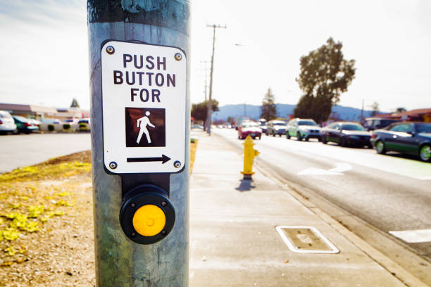 Pedestrian crosswalk button next to busy street in San Jose California.