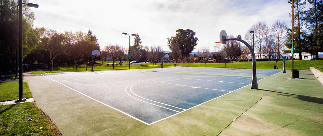 Basketball court in San Jose public park panorama on sunny day, back lit version