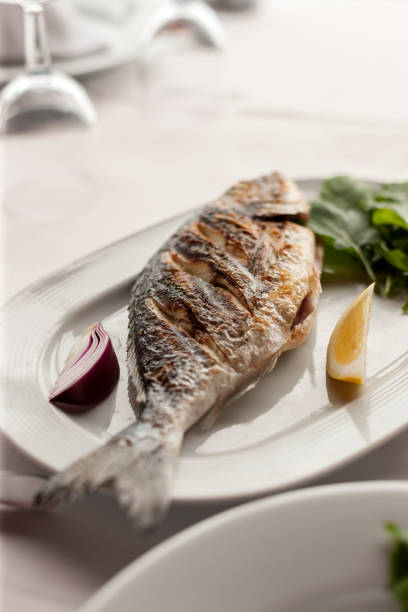 istock Grilled Sea Bream Served on a White Plate with Vegetables 944481460