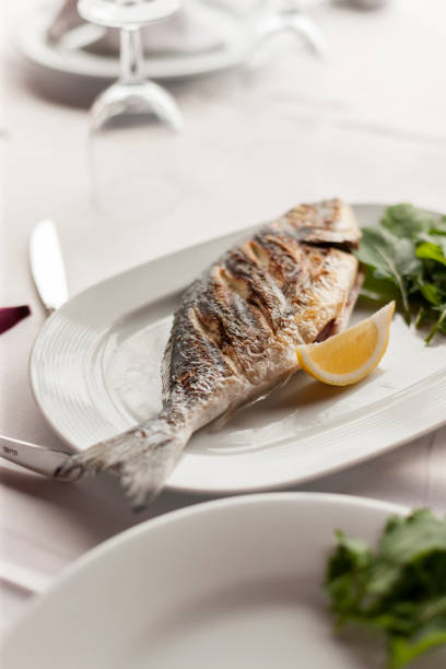 istock Grilled Sea Bream Served on a White Plate with Vegetables 944481486