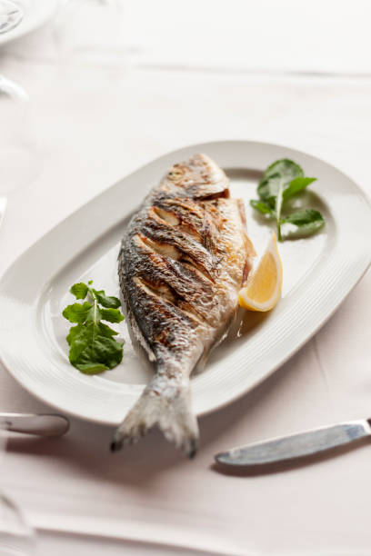 istock Grilled Sea Bream Served on a White Plate with Vegetables 944481512