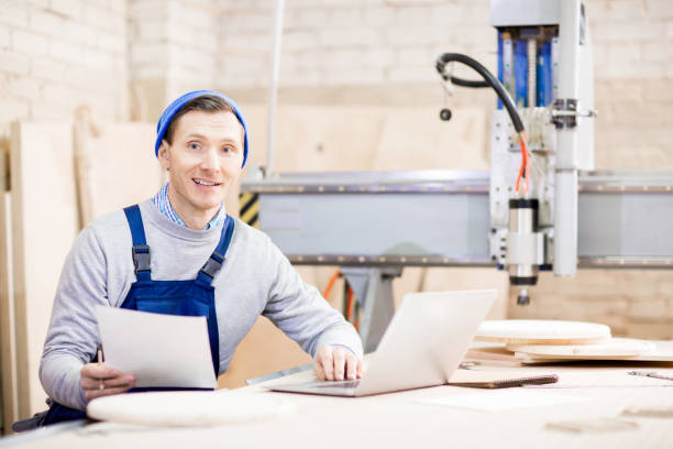 istock Cheerful young craftsman preparing report in workshop 944482470