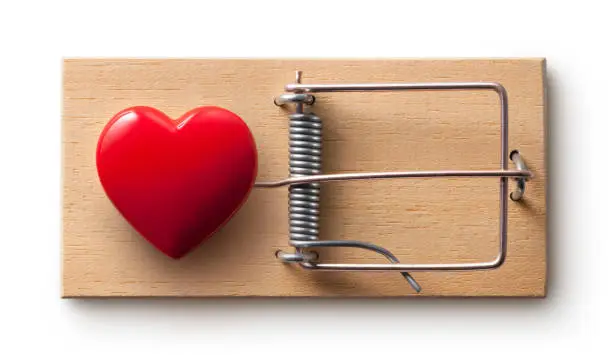 Photo of Love trap. Mousetrap with red heart. Photo with clipping path.