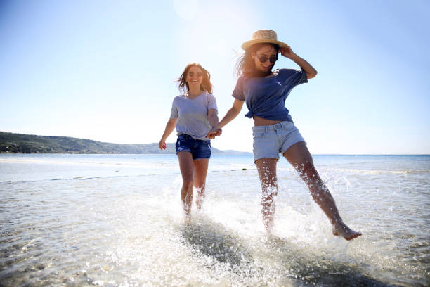 Young friends enjoying their summer vacation on beach stock photo