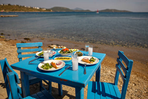 istock Appetizers and Raki or Ouzo Served on a Blue Table on the Beach Besides Beautiful Sea View 944483574