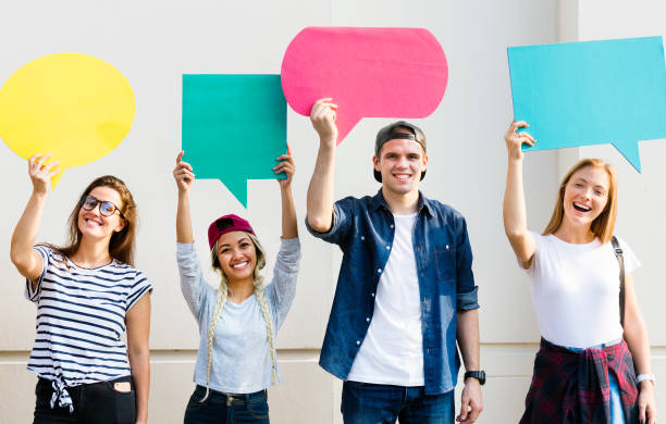 istock Young adult friends holding up copyspace placard thought bubbles 944490378