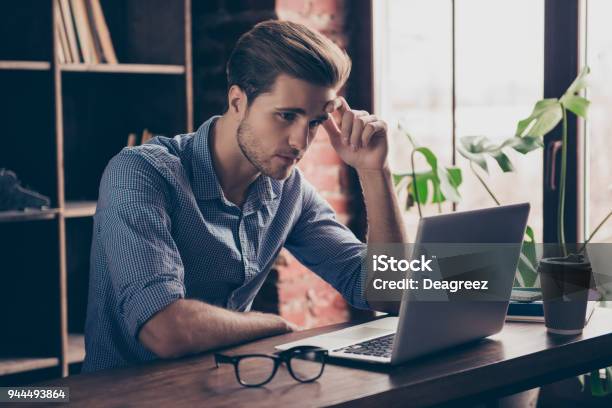 Young Manager In Checkered Shirt Reading Information On The Internet On His Computer Stock Photo - Download Image Now