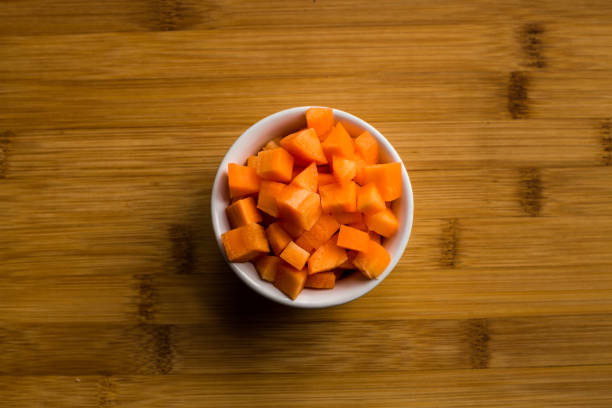istock Diced carrots on wooden chopping board. 944501336
