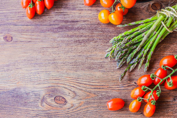 tomatoes, onions and asparaguson a wooden background