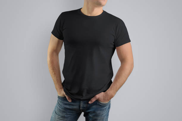 istock Mockup  black T-shirt on a strong man in blue jeans. 944507124