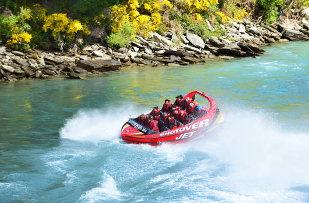 Tourists enjoy a high-speed boat ride on Queenstown's Shotover ,NZ stock photo