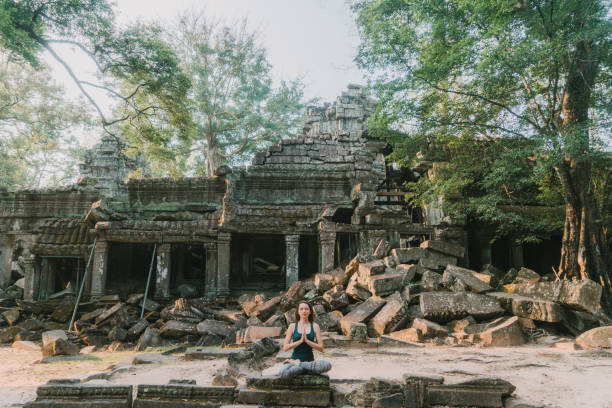 istock Woman doing yoga in  Ta Prohm temple 944518806