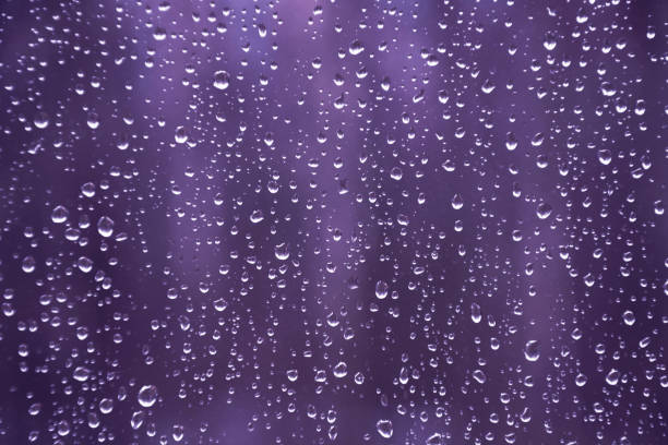 Rain drops on the window on the dark background. Fall. Natural pattern.