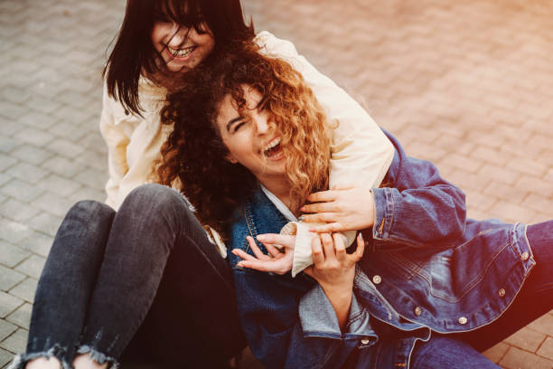 istock Happy girls laughing and and hugging while looking at camera. 944533442