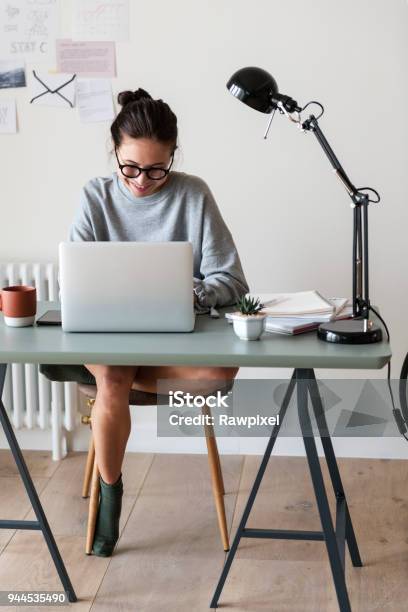 Frau Arbeitet Auf Einem Laptop In Ihrem Haus Stockfoto und mehr Bilder von Arbeiten von Zuhause - Arbeiten von Zuhause, Frauen, Schreibtisch