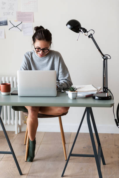 donna che lavora su un laptop nella sua casa - laptop using laptop studying working at home foto e immagini stock