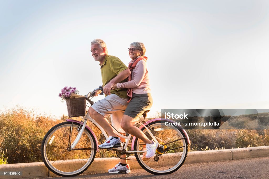 couple de personnes âgées se déplacent avec un vélo en plein air comme des enfants - Photo de Troisième âge libre de droits