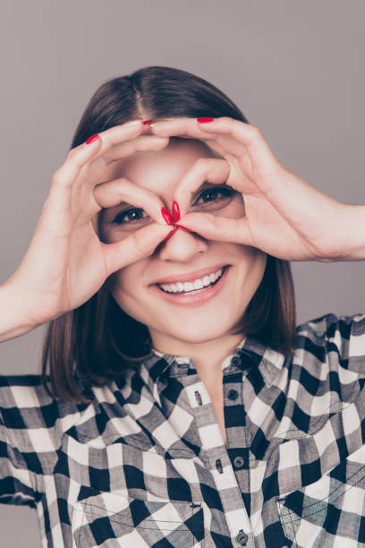 istock Happy laughing woman making binoculars with her hands on gray background 944536196