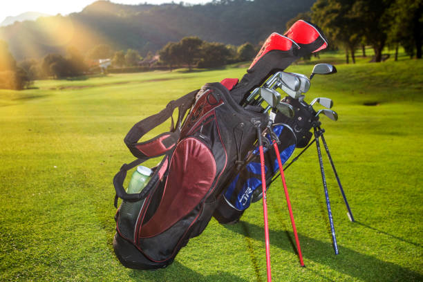istock Golf clubs drivers over green field background. Summer sunset 944542826