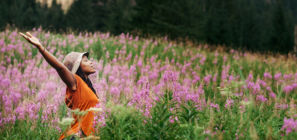 Cropped shot of an attractive young woman standing in a field of flowers in nature