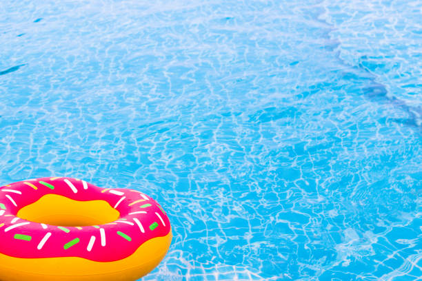 istock Swimming rubber ring with pink donut design above the pool 944550378