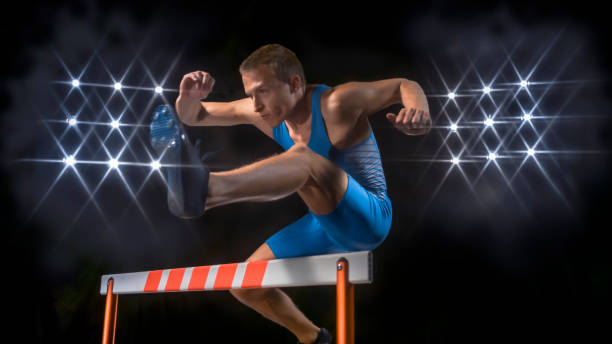 istock Male hurdler jumping over hurdle 944550462