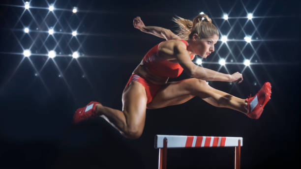 istock Female hurdler jumping over hurdle 944550470