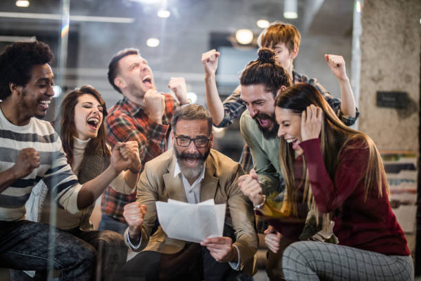 istock Group of cheerful entrepreneurs screaming while celebrating business development in the office. 944550700