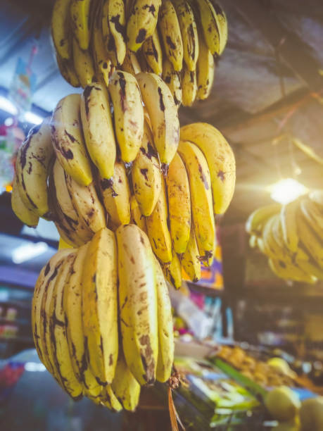istock Bunch of bananas hanging in fruit shop. 944551150