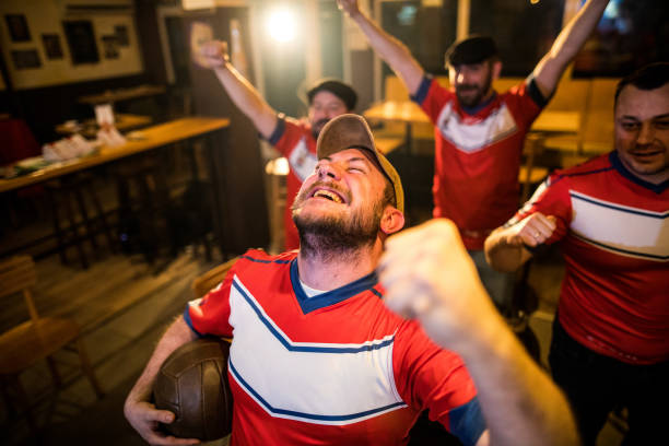 extatiques hommes regardant soocer match dans un bar - fan hooligan screaming shouting photos et images de collection